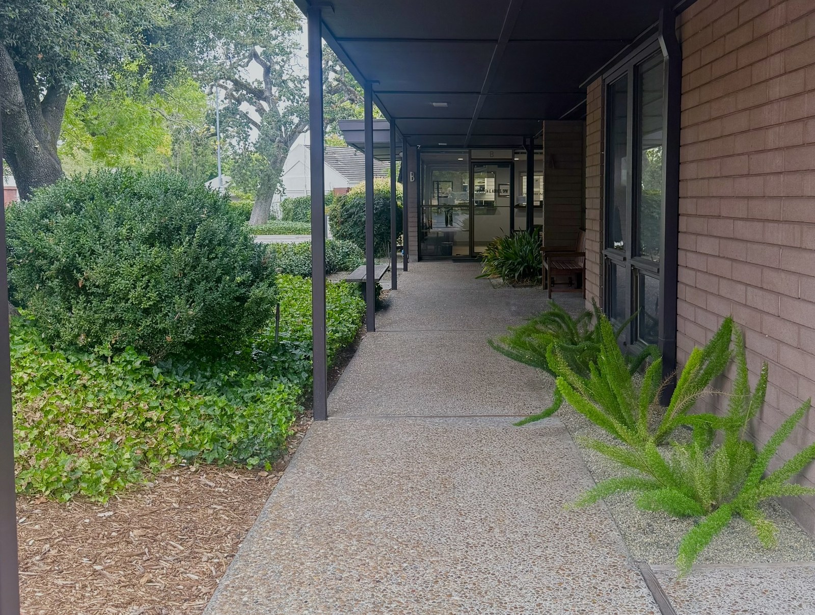 Covered walkway leading toward the glass entrance of Dr. Korves’s Suite B office