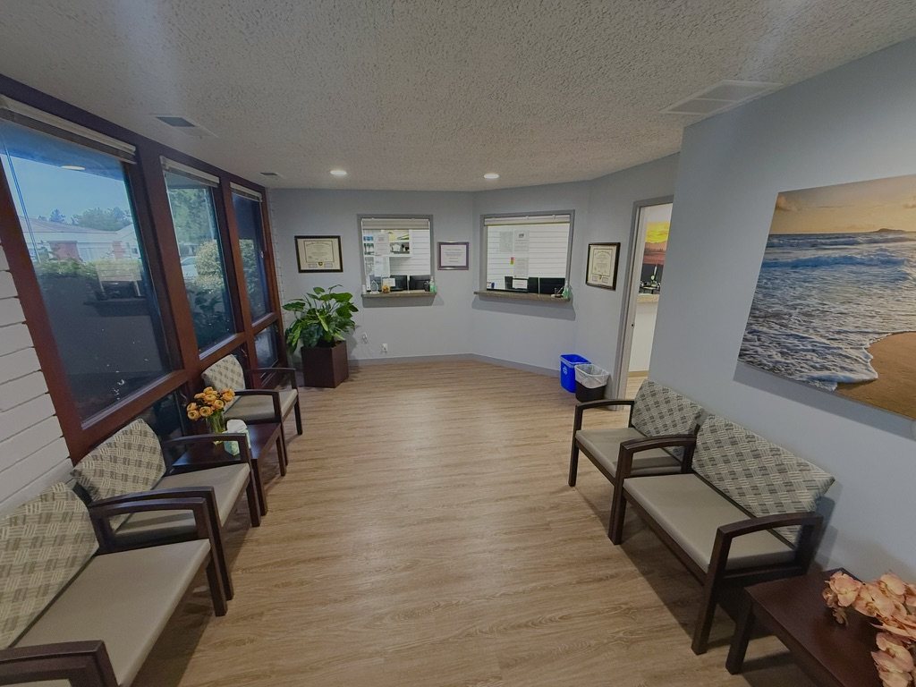 Wide view of the practice waiting room with seating, windows, and framed artwork