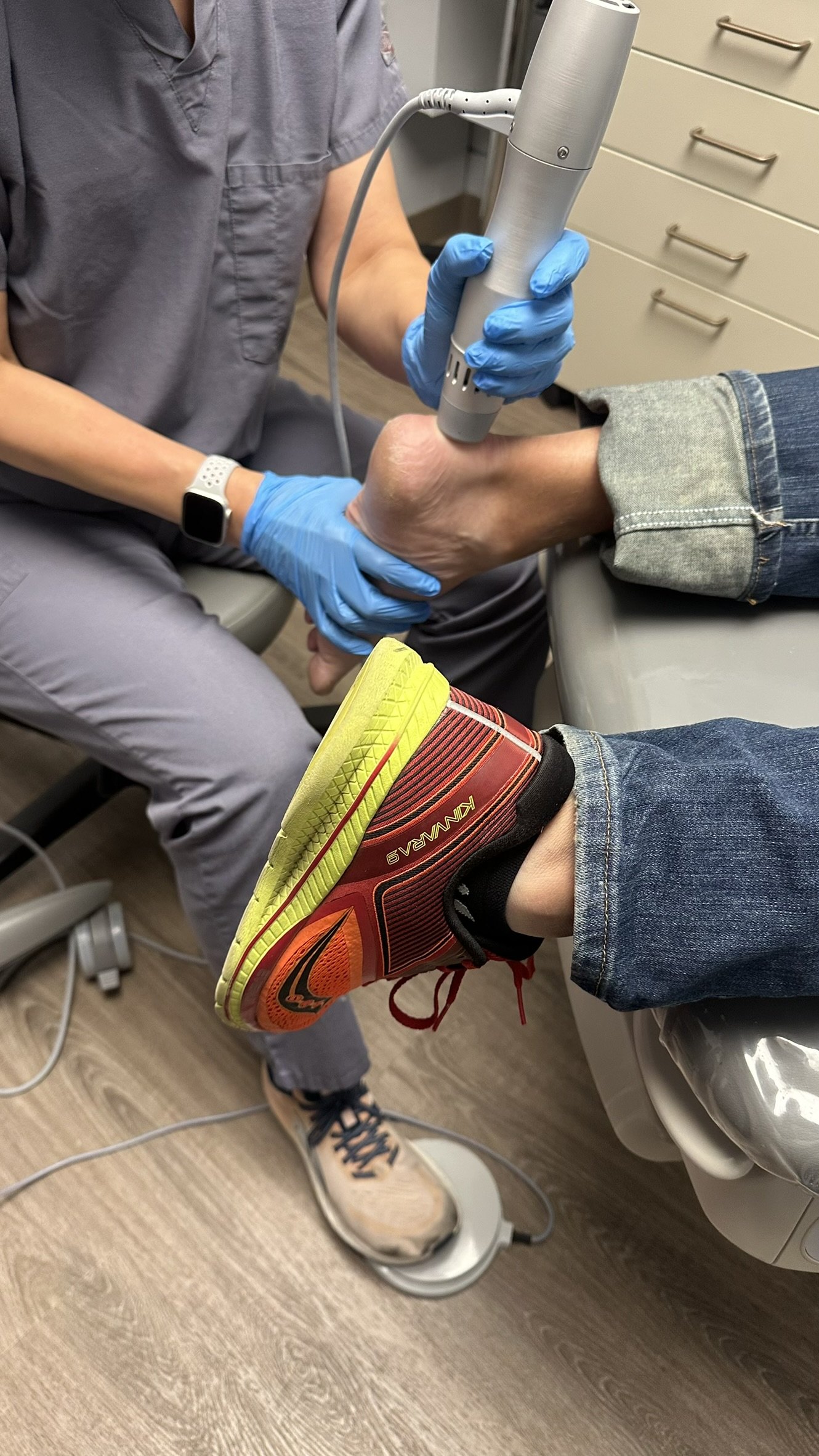 Dr. Korves positioning the ESWT applicator at an anonymous patient’s heel while supporting the foot